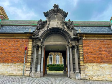 Leuvens 'ın büyüleyici girişinin büyüleyici bir görüntüsü. Güzel bir tuğla duvarın çerçevelediği tarihi binalar. Mimari ve seyahat temalı projeler için ideal. Belçika