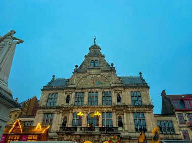 Gent, Belçika - 30 Kasım 2023: Ghents Gotik Mimarisi Gece Görüşü, güzel aydınlatılmış ve şenlikli noel süslemeleri ile süslenmiş. Sahne büyülü bir tatil atmosferini çağrıştırıyor..