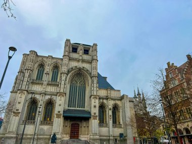 Bu büyüleyici görüntü, Leuven 'in sakin, boş meydanında yer alan güzel bir gotik kiliseyi gösteriyor. Uzun kemerler ve karmaşık pencereler zarif mimari ayrıntıları gösteriyor. Belçika