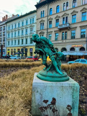 Budapeşte, Macaristan 11 Aralık 2023: 1927 'de Gyorgy Kiss' ten tavuk çalan çocuk. Chicken Stealer 'ın bronz heykeli Budapeşte' de duruyor. Arkasında uzun binalar ve arabalar var. Tavuk hırsızı