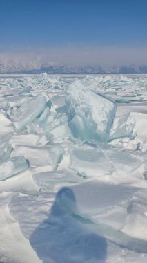 Kışın donmuş göl, günbatımında deniz feneri