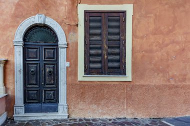 Old destroyed closed door in an orange destroyed wall