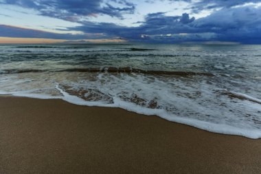 Güzel bulanık deniz dalgaları denizin kumlu kıyılarına karşı