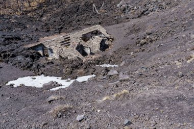 Etna Dağı 'nın yamaçlarında patlayan volkanik küller tarafından gömülüp yok edilen bir ev..
