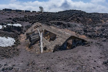 Etna Dağı 'nın yamaçlarında patlayan volkanik küller tarafından gömülüp yok edilen bir ev..