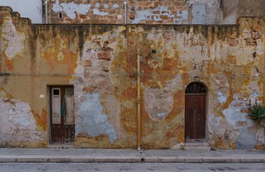 Kimsenin yenilemediği eski kapılarla harap olmuş eski duvarlar..