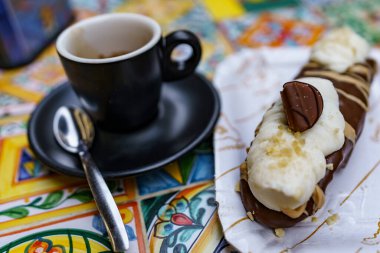 Mükemmel İtalyan espresso eşliğinde lezzetli bir Sicilya cannoli tatlısı..