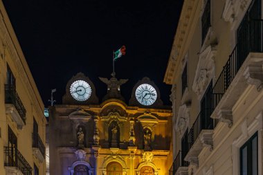 Küçük bir kasabadaki bir binanın kulesine tarih damgası yapıştırılmış eski güzel bir saat..