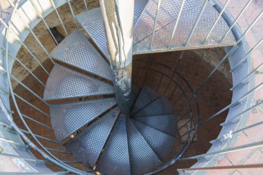 Eski spiral metal merdiven birinci kata çıkıyor, metal parmaklıklı.