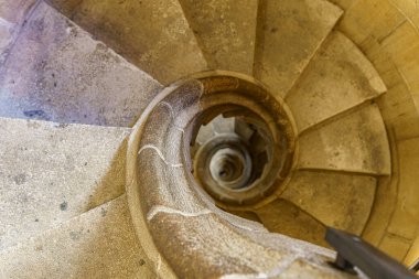 Eski bir binadaki eski, dar, yuvarlak bir merdiven.