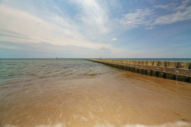 Deniz kenarındaki dalgalar, kumlu güzel bir denizin kıyılarını koruyor.