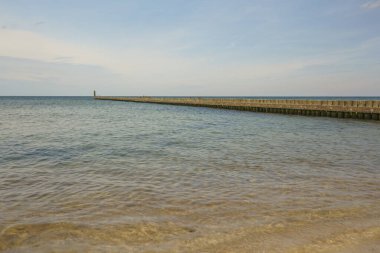 Deniz kenarındaki dalgalar, kumlu güzel bir denizin kıyılarını koruyor.