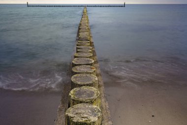Deniz kenarındaki dalgalar, kumlu güzel bir denizin kıyılarını koruyor.