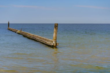 Deniz kenarındaki dalgalar, kumlu güzel bir denizin kıyılarını koruyor.