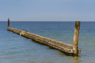 Deniz kenarındaki dalgalar, kumlu güzel bir denizin kıyılarını koruyor.