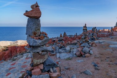 Deniz ufkunun manzarası, ön planda çok yüksek taş yığınları var..