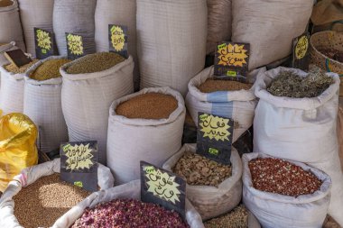 Arap dilinde tarif edilen küçük bir şehir pazarında büyük miktarlarda satılan renkli baharatlar..