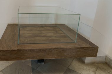 Boş bir odadaki taş tezgahın üzerinde boş bir cam vitrin.