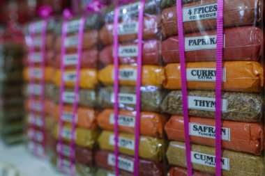 Renkli ve aromatik baharat yığınları, folyo paketlerinde paketlenmiş.