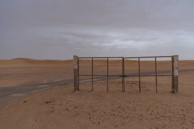 Tek bir kapalı garaj kapısı. Açık çölde hiç çit kalmadı.