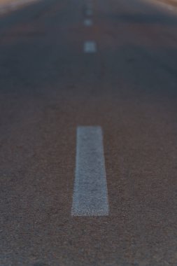 Çölün düz bir bölümünden ufka uzanan asfalt bir yol.