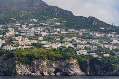 Deniz kenarındaki bir kayanın üzerine inşa edilmiş tek katlı güzel bir deniz kenarı yerleşimi..