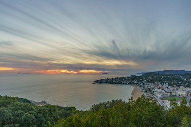 Gün batımında bulanık bulutlarla küçük bir sahil kasabasının güzel manzarası