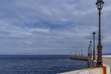 Deniz kıyısındaki güzel lambaları deniz ve fırtınalı gökyüzünün arka planında görmek