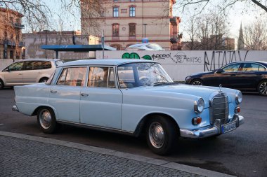 Berlin, 3 Mart 2025, açık mavi Mercedes Benz W110, halk arasında küçük kuyruk yüzgeci olarak bilinir, kaldırımın kenarına park edilmiş.. 