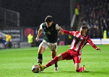Exeter City forveti Jay Stansfield (9) 31 Ekim 202 'de Home Park, Plymouth, İngiltere' de oynanan Sky Bet Lig 1 karşılaşmasında orta saha oyuncusu Joe Edwards (8) ile oynadı.