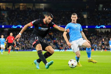 Sevilla 'dan Rafa Mir # 12 UEFA Şampiyonlar Ligi maçında Manchester City - Sevilla maçında Sergio Gomez # 21 Manchester City' nin izlediği topu geçiyor.