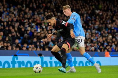 Sevilla 'dan Alex Telles # 3 UEFA Şampiyonlar Ligi maçında Manchester City - Sevilla maçında Manchester City - Manchester Stadyumu, İngiltere 2 Kasım 202' de Cole Palmer # 80 'i oyalamaya çalışıyor.
