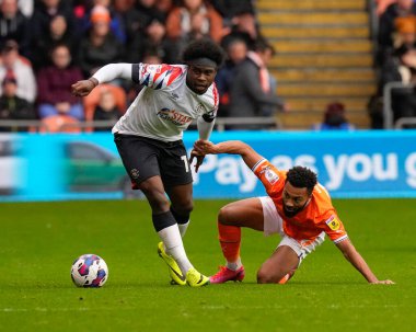 Blackpool 'dan 27 numaralı Grant Ward, 5 Kasım 202' de Bloomfield Road, Blackpool 'da Luton Town' a karşı oynanan Sky Bet Şampiyonası maçında Luton Town 'un 17 numaralı oyuncusu Pelly Ruddock Mpanzu ile top için yarışıyor.