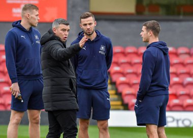 Plymouth Argyle teknik direktörü Steven Schumacher ile Plymouth Argyle orta saha oyuncusu Sam Cosgrove (16) Plymouth Argyle orta saha oyuncusu Matt Butcher (7) ve Plymouth Argyle orta saha oyuncusu Adam Randell (20) sahaya çıkıyor ve Emirates FA Cup Fi 'si sırasında sahaya teftiş ediyor.