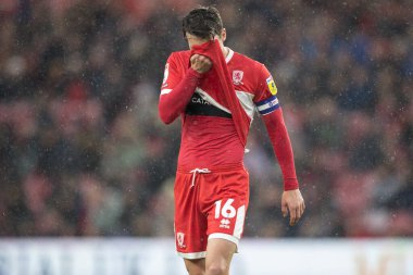 Middlesbrough 'dan Jonathan Howson # 16 numaralı depresif kişi, 5 Kasım 202' de Riverside Stadyumu, Middlesbrough, İngiltere 'de oynanan Middlesbrough-Bristol maçında gömleğiyle yüzünü kapatıyor.