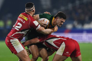 Avustralyalı Nathan Cleary, Rugby Ligi Dünya Kupası 2021 Çeyrek final karşılaşmasında Lübnanlı Charbel Tasipale ve Khaled Rajab tarafından John Smith Stadyumu, Huddersfield, Birleşik Krallık 'ta oynanan 4 Kasım 202' de oynanan Avustralya-Lübnan maçında yenildi.