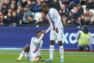Crystal Palace 'ın 3 numaralı oyuncusu Tyrick Mitchell 6 Kasım 202' de Londra Stadyumu 'nda oynanan Premier League maçı sırasında Crystal Palace' ın 11 numaralı oyuncusu Wilfried Zaha 'nın ayağa kalkmasına yardım ediyor.