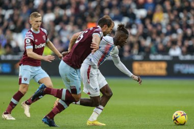 Crystal Palace 'ın 11 numaralı oyuncusu Wilfried Zaha, 6 Kasım 202' de Londra 'daki Londra Stadyumu' nda oynanan Premier League maçında West Ham United - Crystal Palace maçında Craig Dawson # 15 West Ham United 'ın baskısı altında topla koşuyor.