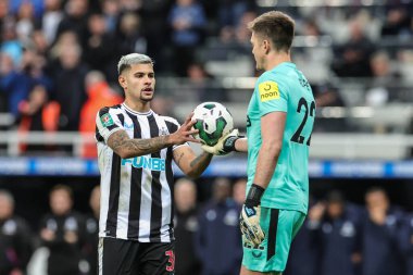 Newcastle United takımının 22 numaralı oyuncusu Nick Pope, Newcastle United 'ın 39 numaralı oyuncusu Bruno Guimares' i geçiyor. Top, Carabao Kupası üçüncü tur karşılaşmasında penaltısını alıyor. Newcastle United, Crystal Palace 'a karşı, St.James' s Park, Newcastle, İngiltere