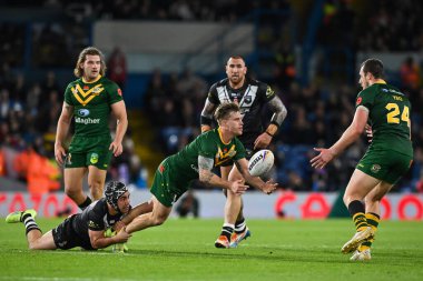 Avustralyalı Cameron Munster, Yeni Zelandalı Jahrome Hughes 'un Rugby Ligi Dünya Kupası 2021 Yarı Finali' nde Avustralya ile Yeni Zelanda arasındaki 11 Kasım 202 'de oynanan Elland Road, Leeds, İngiltere' de oynanan karşılaşmada aldığı mücadeleye rağmen topu atıyor.