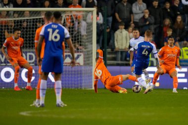 Blackpool 'dan Sonny Carey # 16, Wigan Atletizm Şampiyonası' nda Wigan Athletic 'in 12 Kasım 202' de Wigan, Wigan 'da Blackpool' a karşı oynadığı maçta Tom Naylor # 4 'den şutu engelledi.