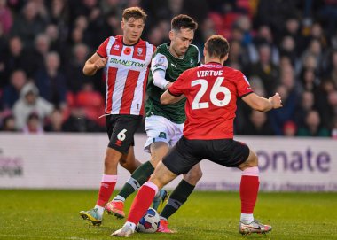 Plymouth Argyle forveti Ryan Hardie (9) Lincoln City orta saha oyuncusu Matty Virtue (26) tarafından Gelder Group Sincil Bank Stadyumu 'nda oynanan Lincoln City - Plymouth Argyle maçında savunuluyor.