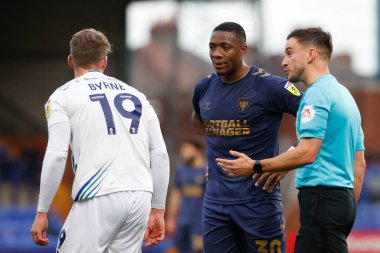 Hakem Thomas Kirk, 19 Kasım 2022 'de İngiltere' nin başkenti Birkenhead 'de oynanan Gökyüzü İddia Ligi 2 maçında Tranmere Rover' ın 19 numaralı oyuncusu Paul Kalambayi ile konuştu.