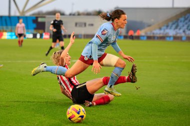 Hayley Raso #13 of Manchester City is tackled by Louise Griffiths #6 of Sunderland during the FA Womens Continental League Cup match Manchester City Women vs Sunderland AFC Women at Etihad Campus, Manchester, United Kingdom, 27th November 2022 clipart