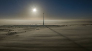 Güneş, yoğun sis örtüsü olarak Emley Moor İletim Kulesi 'nde yükseliyor ve 29 Kasım 2022' de Huddersfield, Birleşik Krallık 'a engel oluyor.