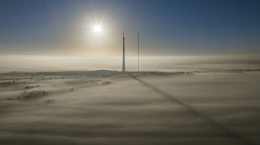 Güneş, yoğun sis örtüsü olarak Emley Moor İletim Kulesi 'nde yükseliyor ve 29 Kasım 2022' de Huddersfield, Birleşik Krallık 'a engel oluyor.
