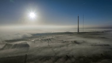 Güneş, yoğun sis örtüsü olarak Emley Moor İletim Kulesi 'nde yükseliyor ve 29 Kasım 2022' de Huddersfield, Birleşik Krallık 'a engel oluyor.