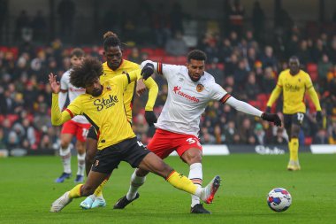 Watford 'dan 4 numaralı Hamza Choudhury 11 Aralık 2022' de Watarage Road, Watford, Birleşik Krallık 'ta oynanan Sky Bet Şampiyonası' nda Hull City 'den 33 numaralı Cyrus Christie' yi yere serdi.