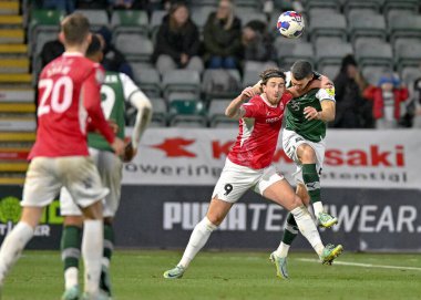 Plymouth Argyle defansı James Wilson (5) ve Morecambe forvet Cole Stockton (9), Plymouth Argyle-Morecambe maçında top için 17 Aralık 2022 tarihinde Home Park, Plymouth, İngiltere 'de karşı karşıya geldiler.