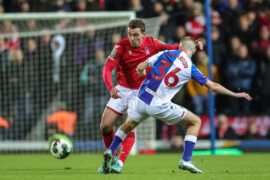 Harry Toffolo of Nottingham Forest asses the ball under pressure from Adam Wharton of Blackburn Rovers during the Carabao Cup Fourth Round match Blackburn Rovers vs Nottingham Forest at Ewood Park, Blackburn, United Kingdom, 21st December 2022